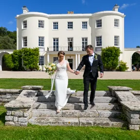 bride and groom walking down steps at Rockbeare Manor by Andrew Hazard Photography
