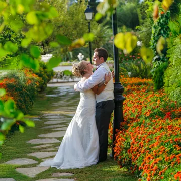 Simon and Helen wedding embracing surrounded by flowers in the gardens of A Royal Hideaway Hotel Formentor by Andrew Hazard