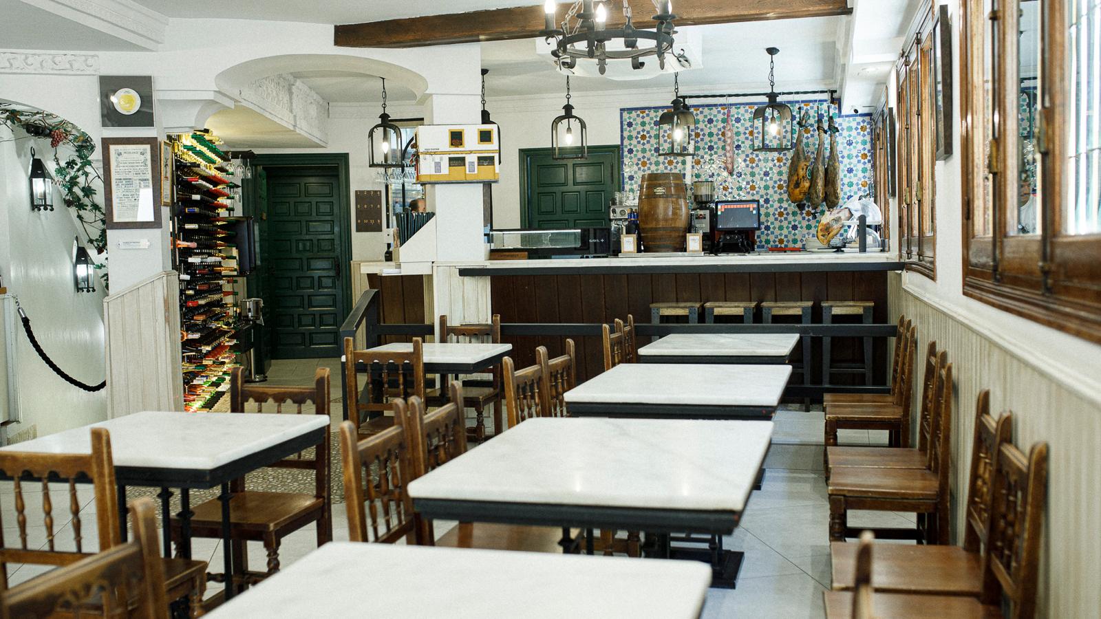 Interior de Taberna Rafaé, con mesas, barra y azulejos tradicionales