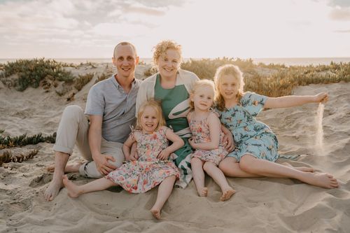 Photo of Amanda sitting on a beach with her family