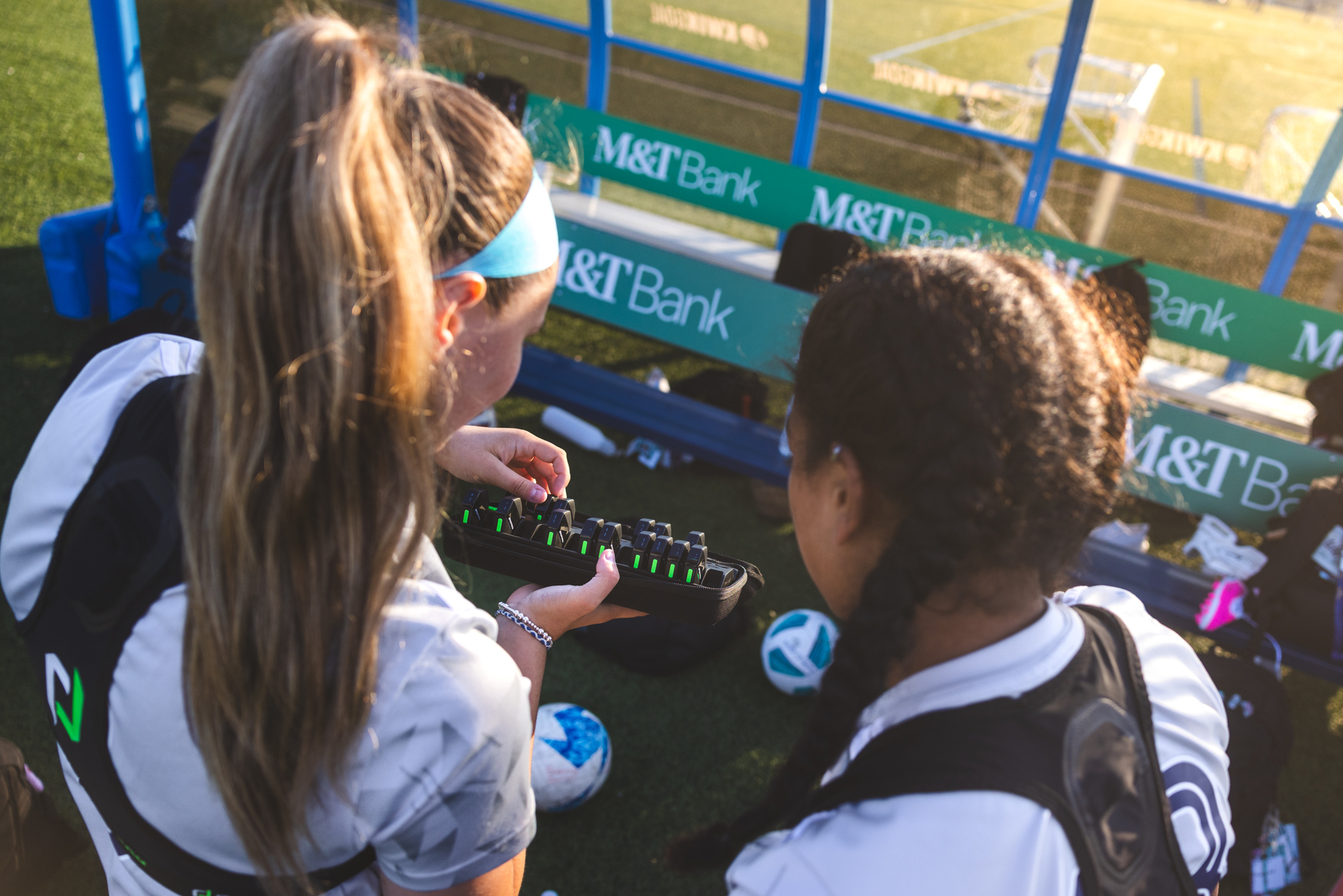 SUSA FC players collecting PlayerData EDGE Air trackers from the charging case pitchside