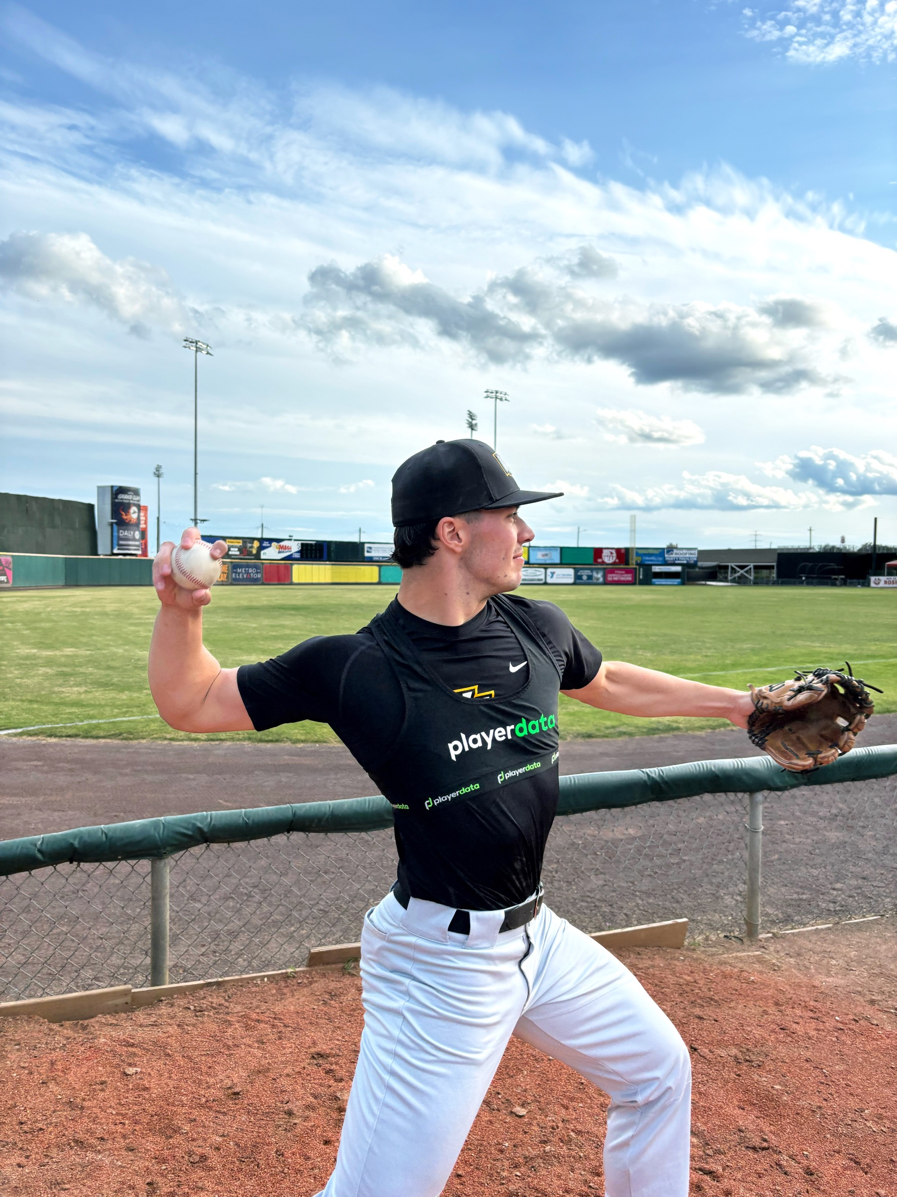Baseball player wearing a PlayerData vest while throwing