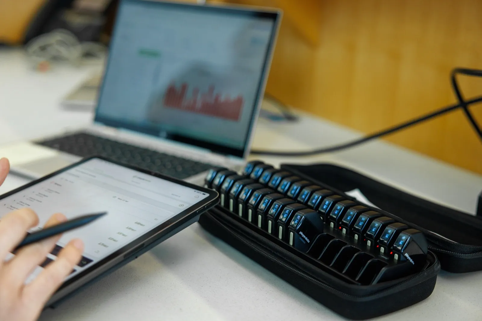 Coach reviewing PlayerData metrics on a tablet next to a case of EDGE Air units