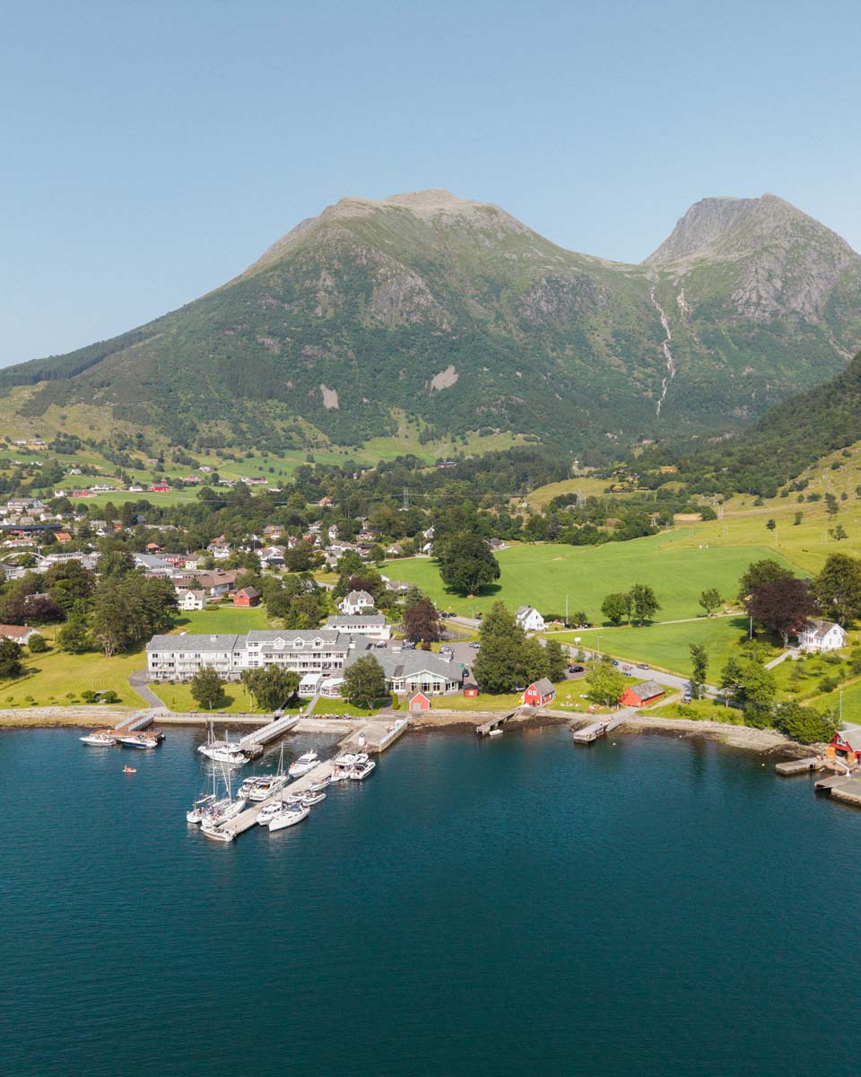 Rosendal Fjordhotel med fjord og fjell frå lufta. Foto: Jon Aga / Visit Hardangerfjord