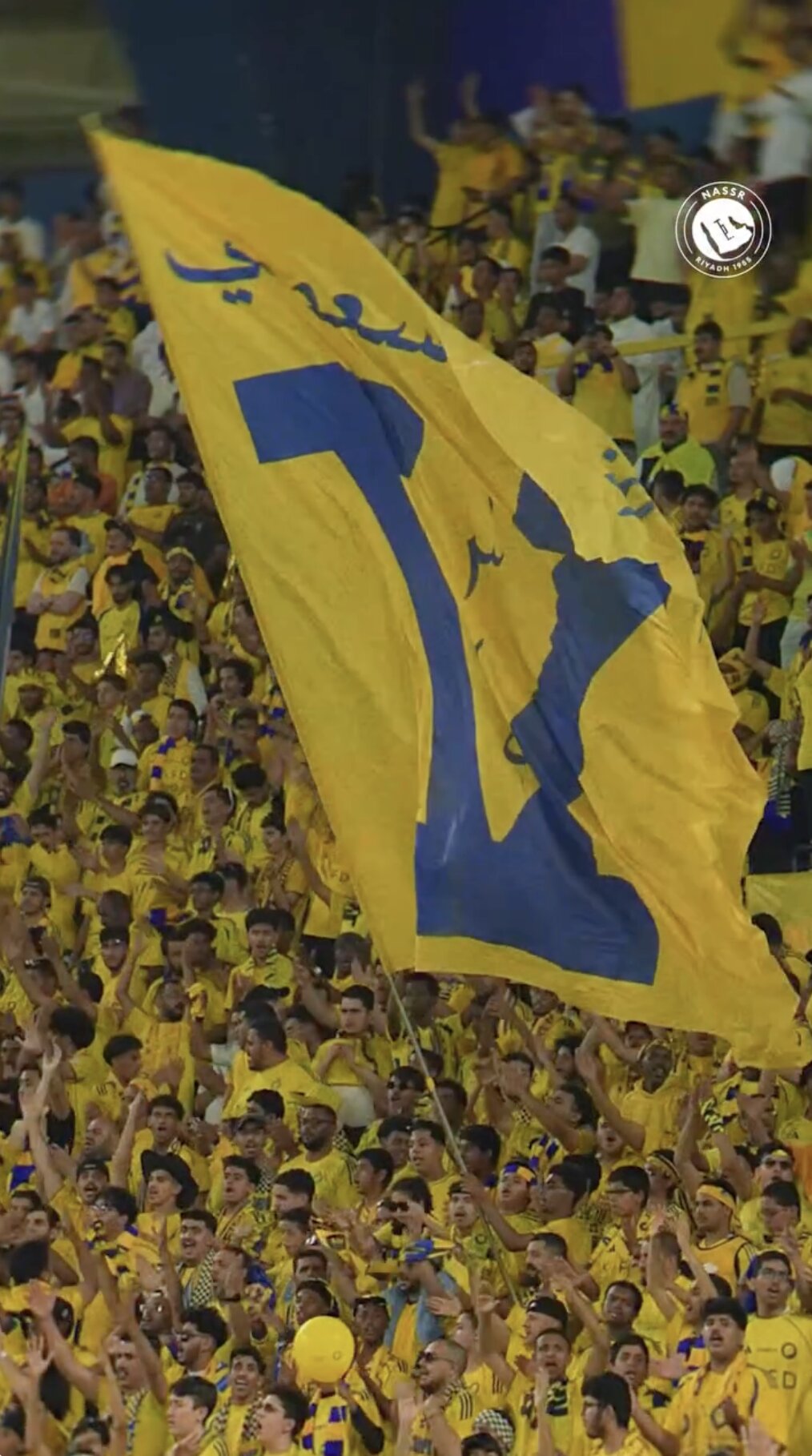 Al Nassr — supporters raising the giant V flag in the stands