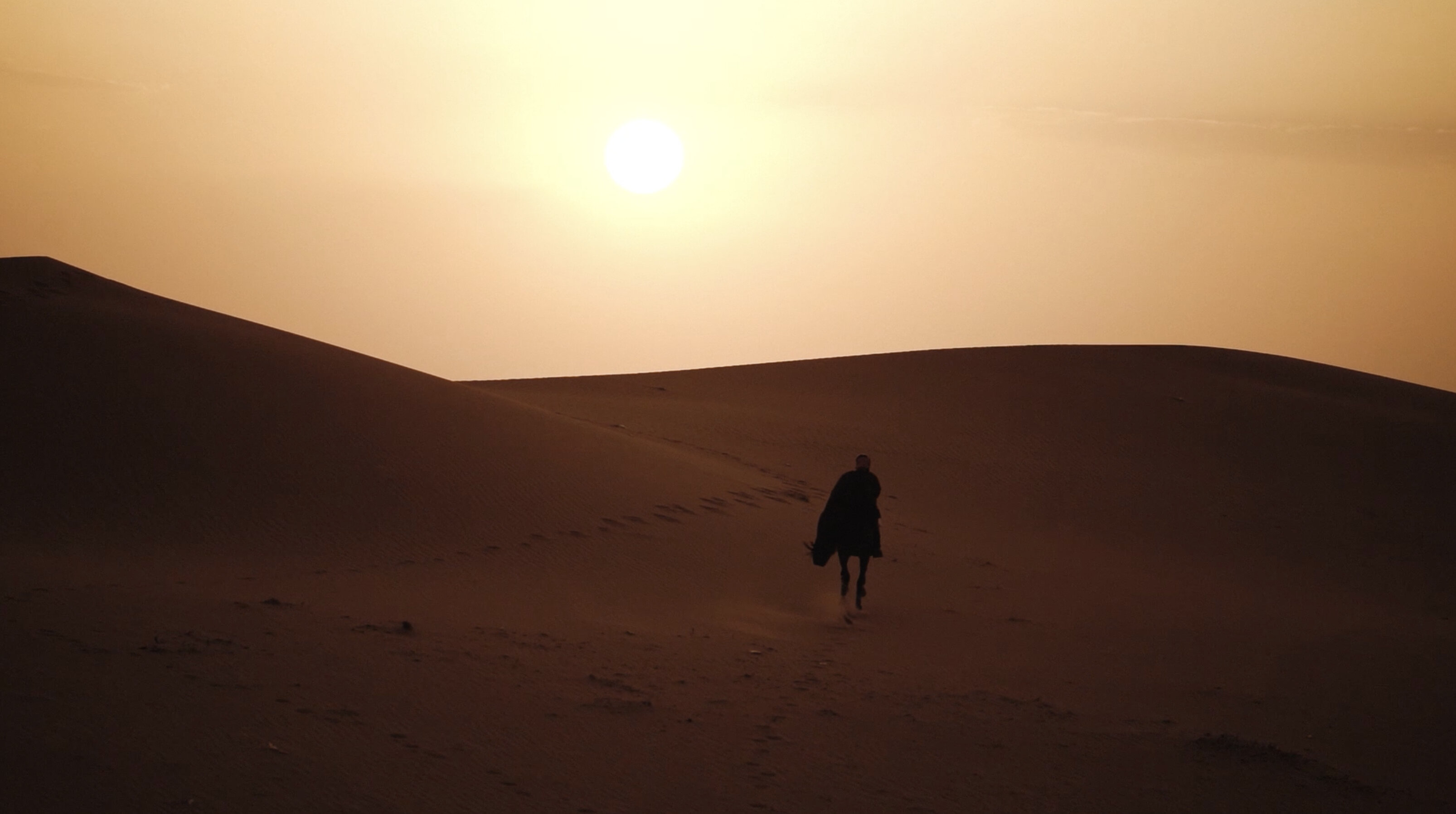 Al Nassr — lone rider on the desert dunes at sunset