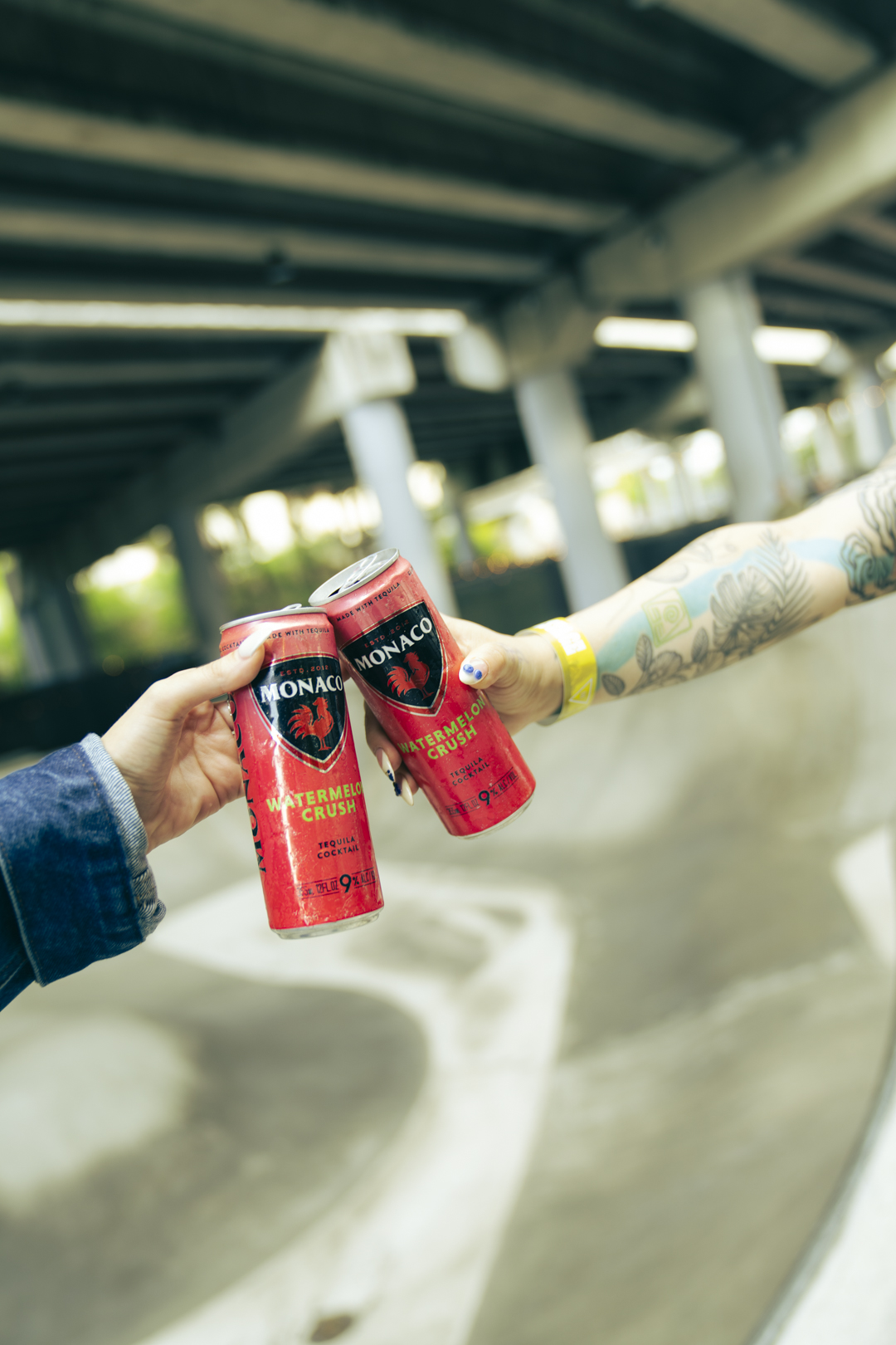 Two arms outstretched making a toast holding Monaco Watermelon Crush cocktails