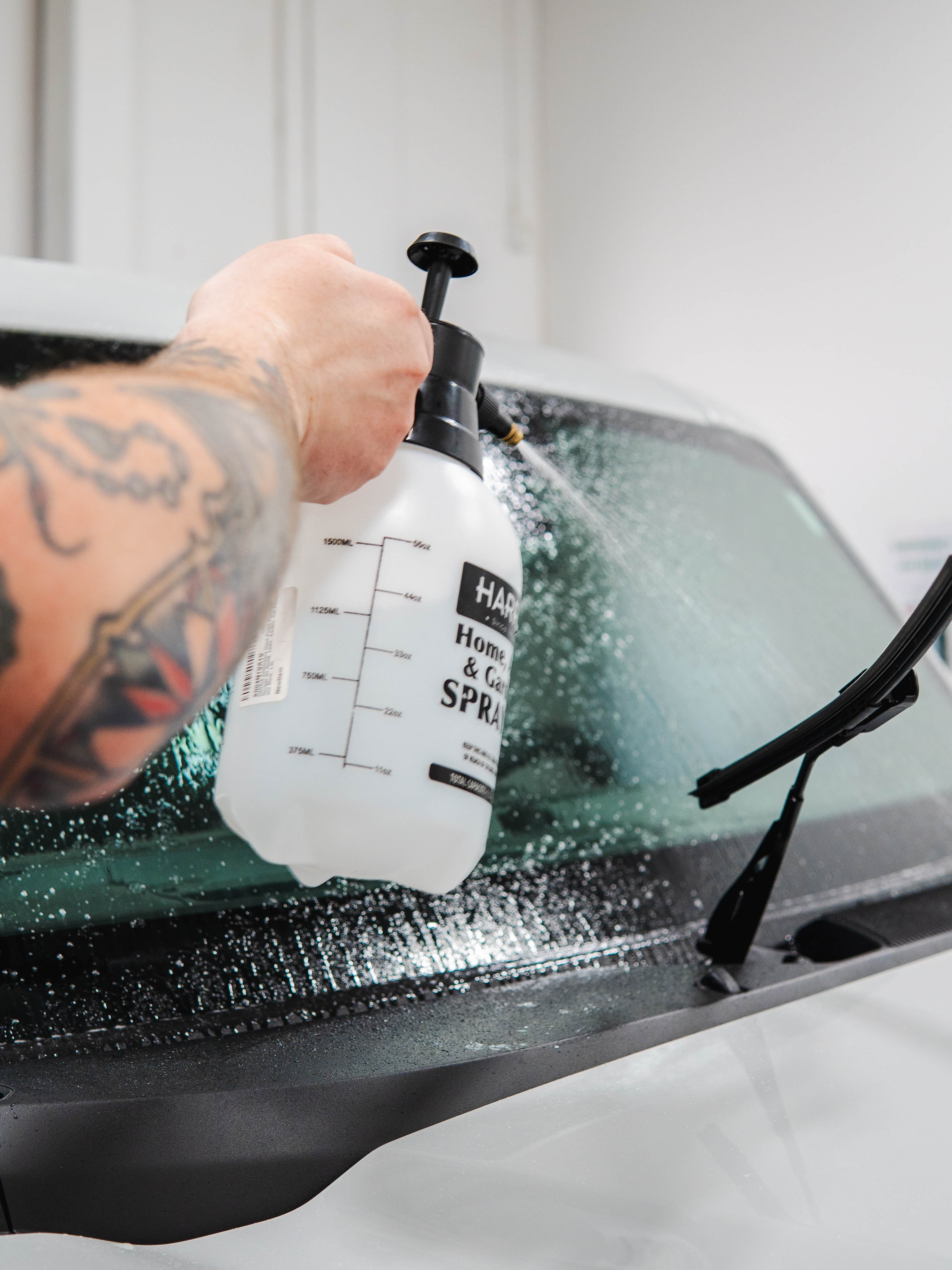 spraying the windshield to ensure that it is clean and well maintained