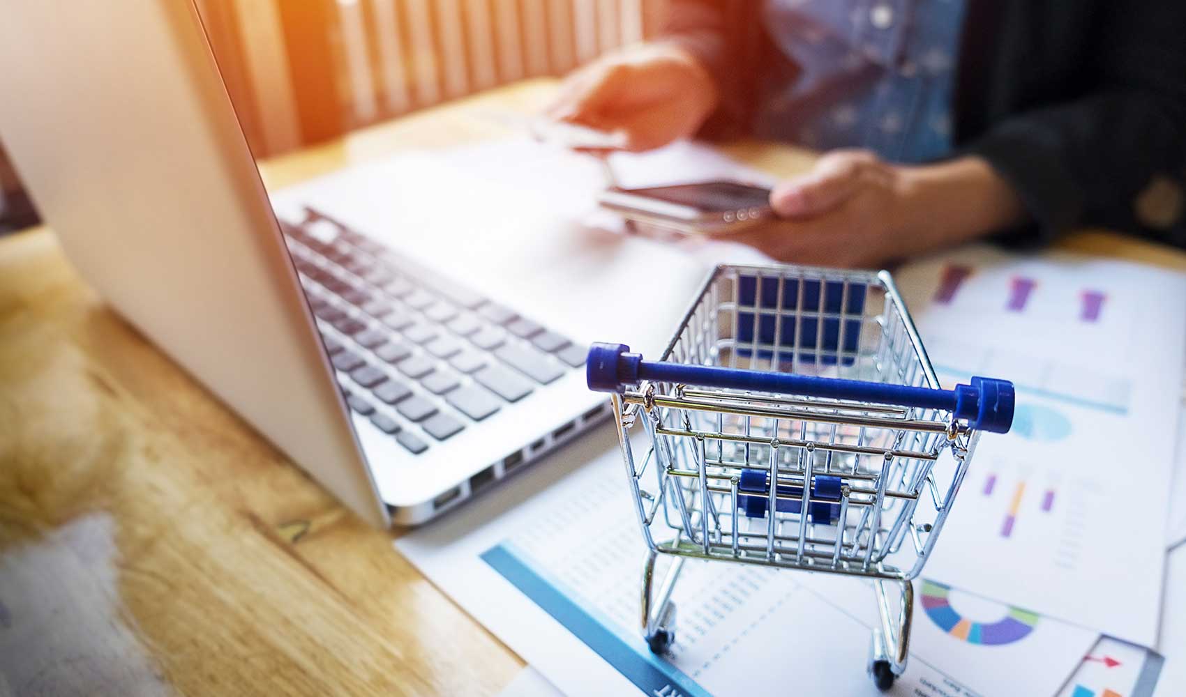 a shopping cart beside a laptop