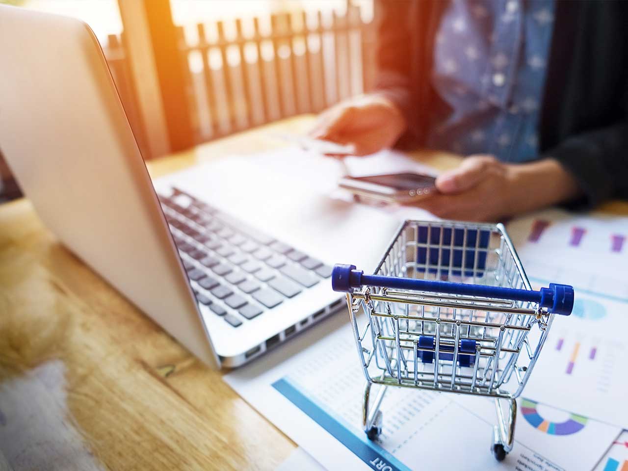 a shopping cart beside a laptop