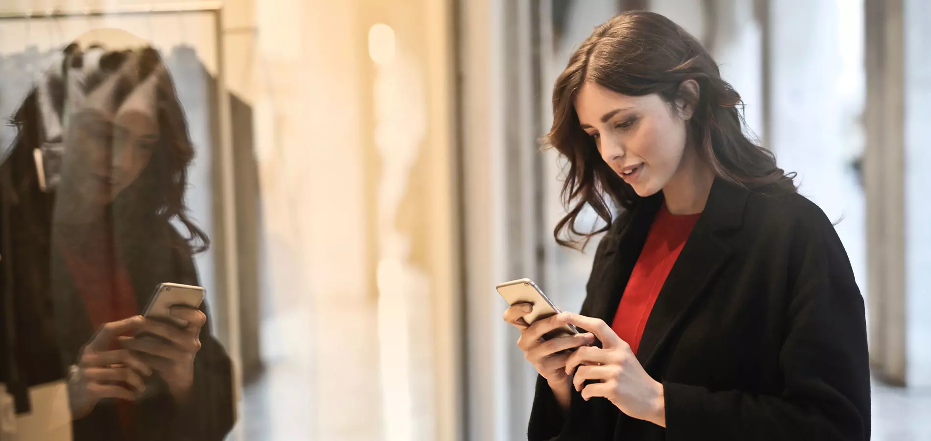 Woman in black coat using smartphone