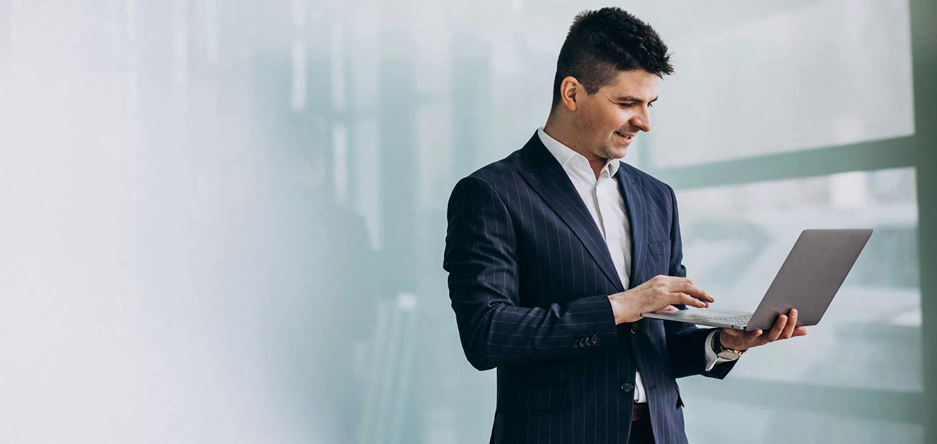 Business man standing while using a laptop