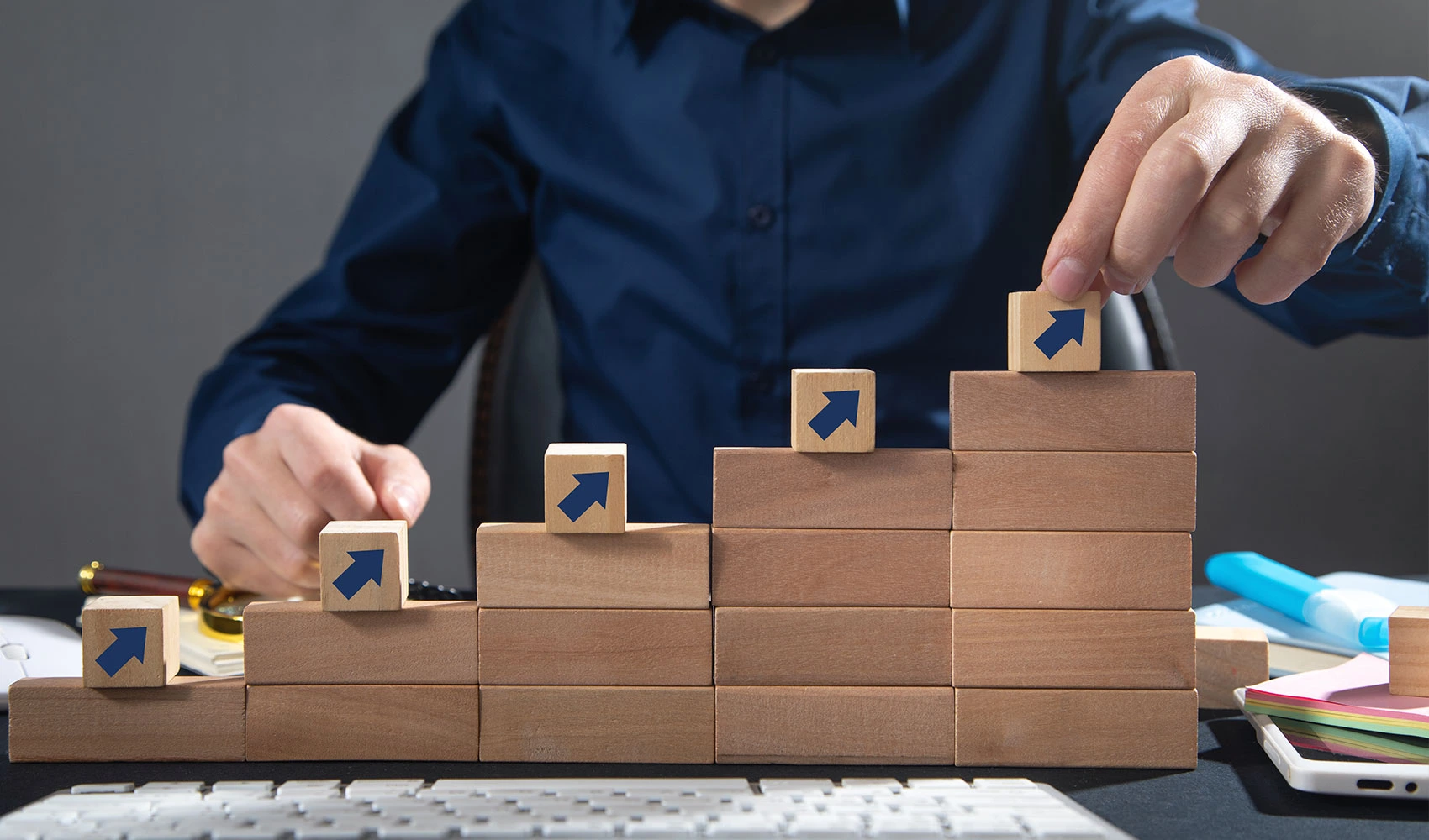 Man stacking wooden cubes with arrows