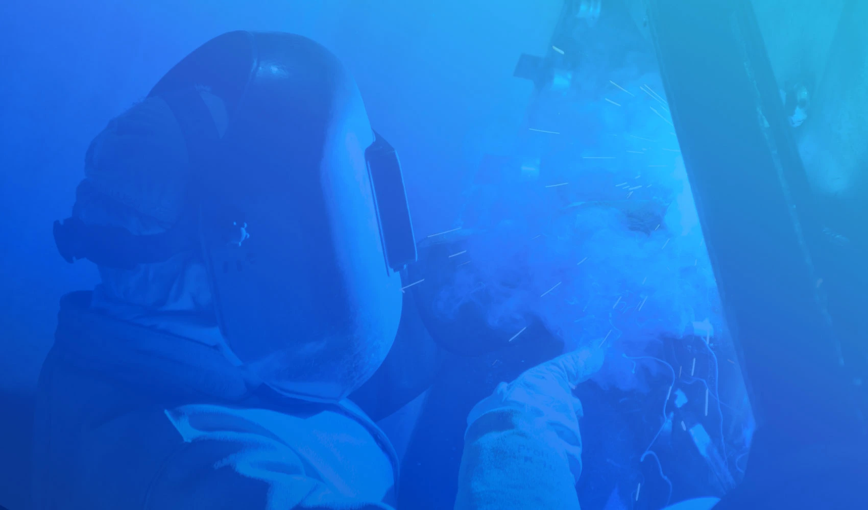 Photo of a man wearing a welding mask with blue aqua gradient overlay
