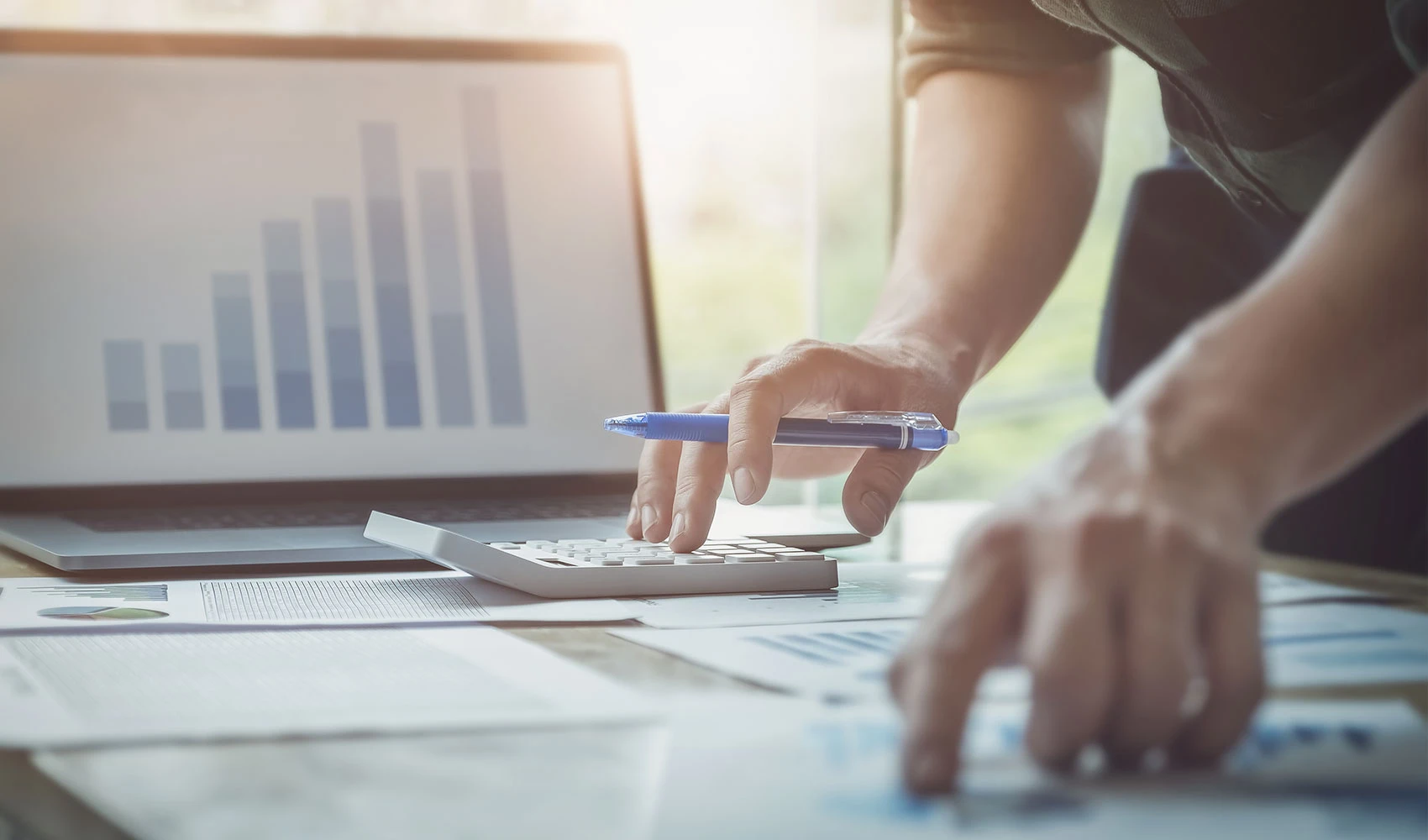 Business man using calculator reviewing project budget