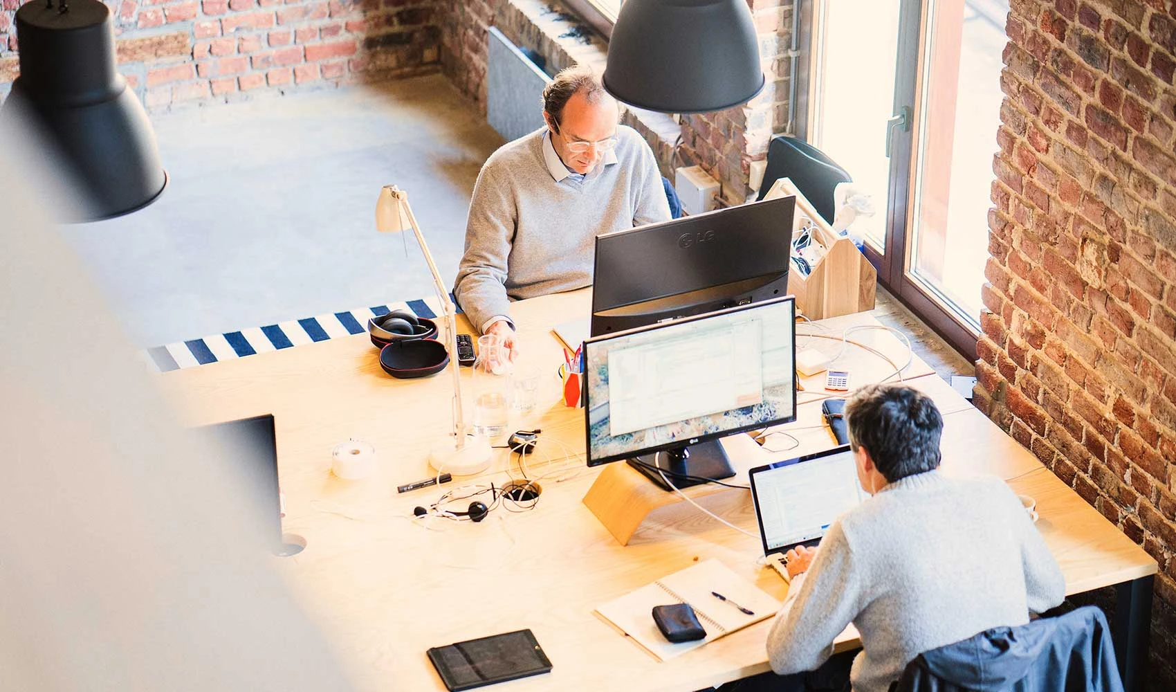 Two employees working with their computers in the desk