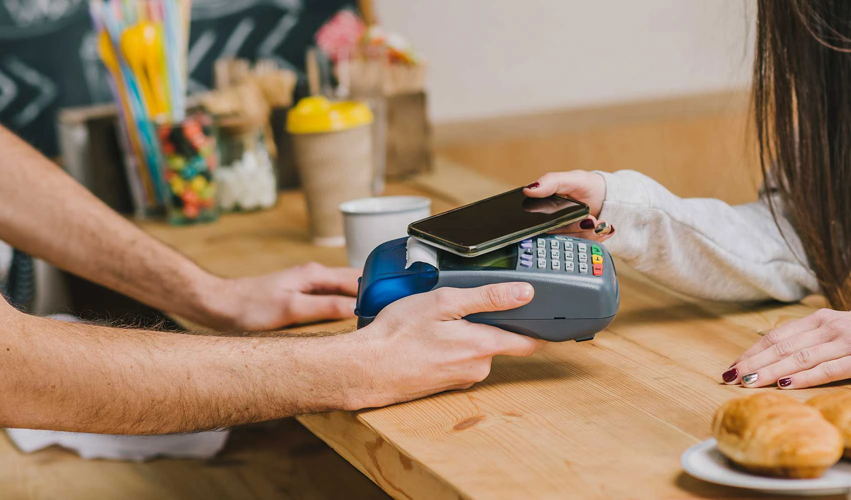 Woman paying with smartphone in cafe