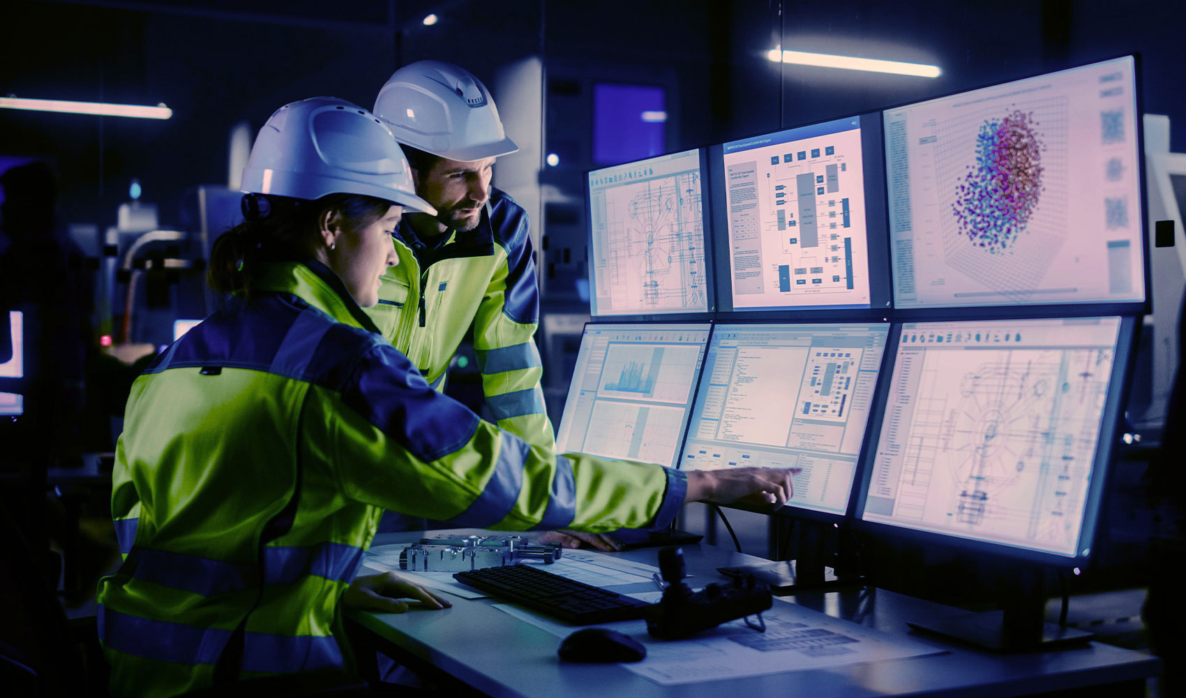 Two engineers with uniform focusing on computer screens
