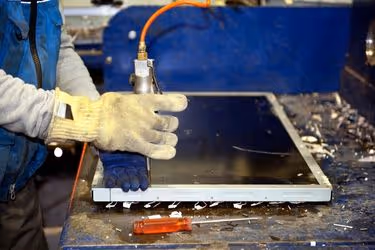E-Waste disposal center - Man disassembling a monitor