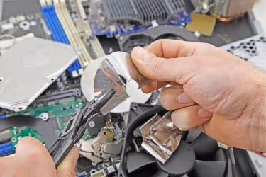 person taking apart a hard disk