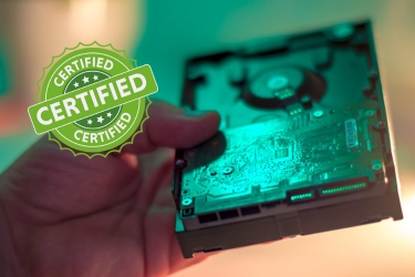 Hand holding a hard disc and a seal that says "certified"