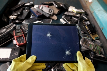 Man holding a recycled tablet in the recycling center