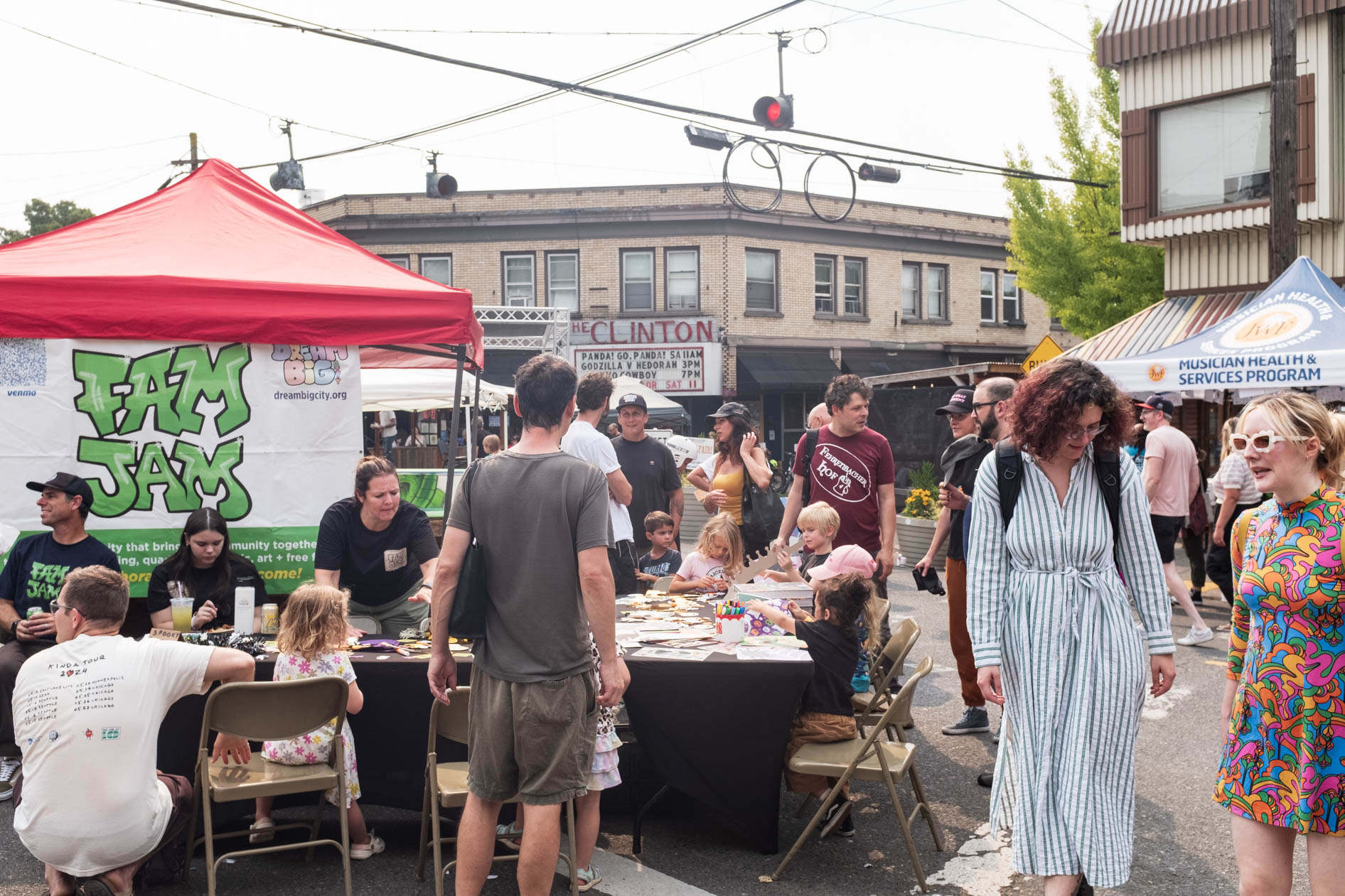 a lively street fair during a sunny summer day in Southeast Portland