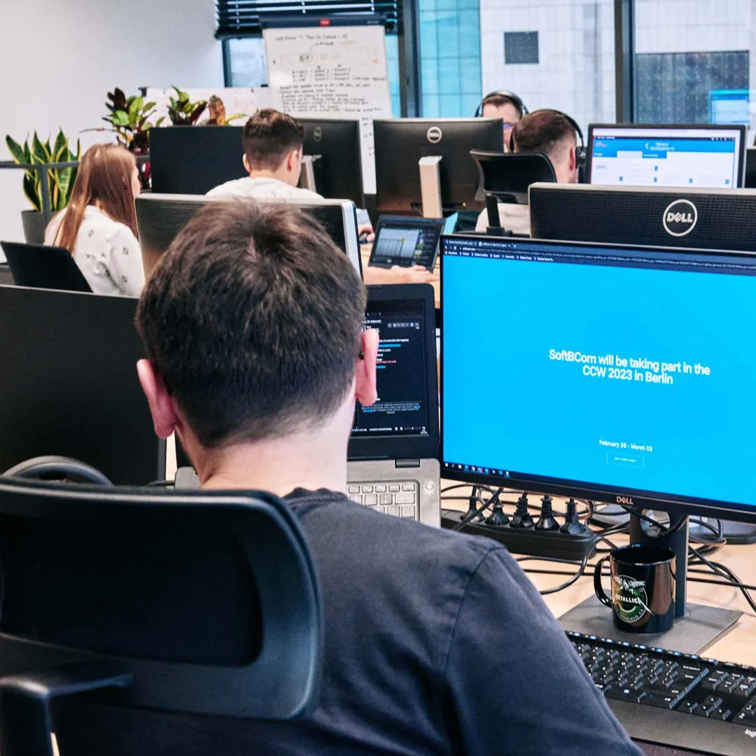 A man sitting in front of a computer monitor.