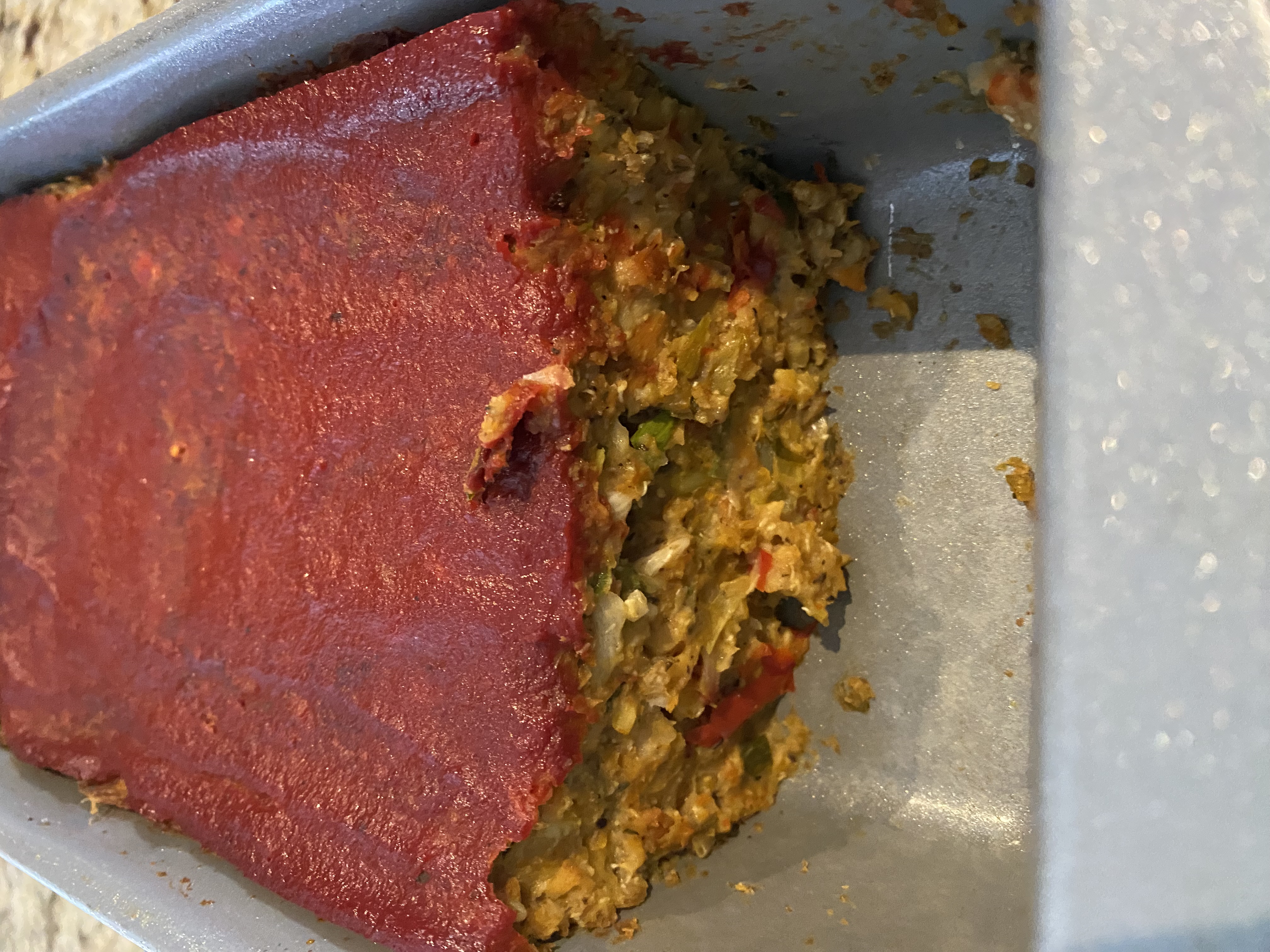 Veggie meatloaf in pan with tomato sauce
