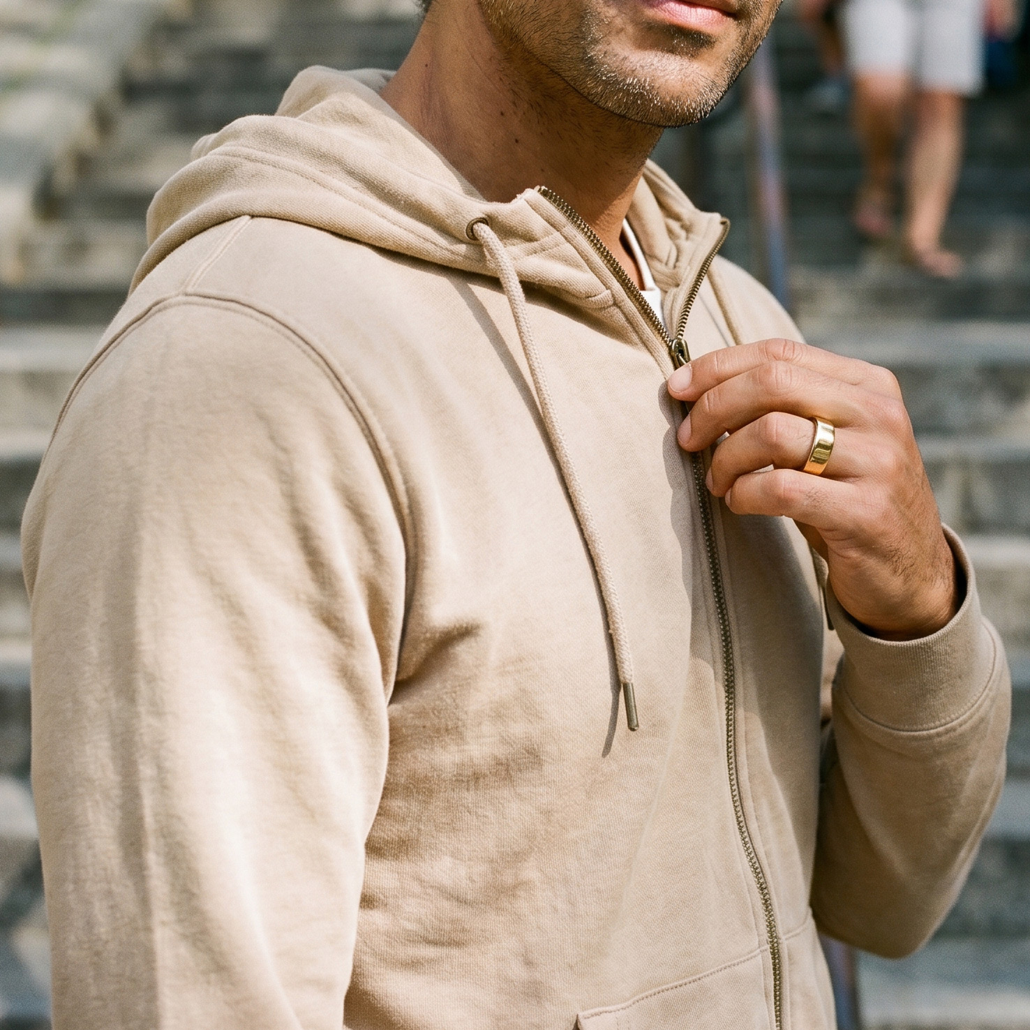 Man on stone steps wearing the Circular Ring 2 in gold titanium