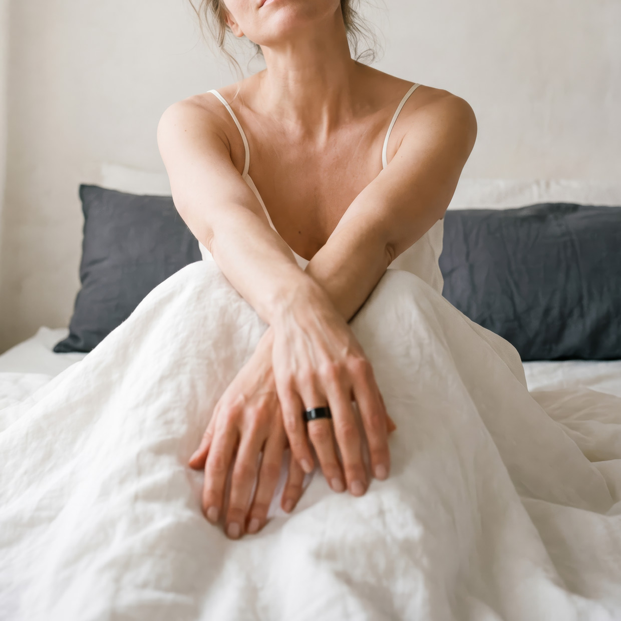 Woman waking up wearing the Circular Ring in black titanium