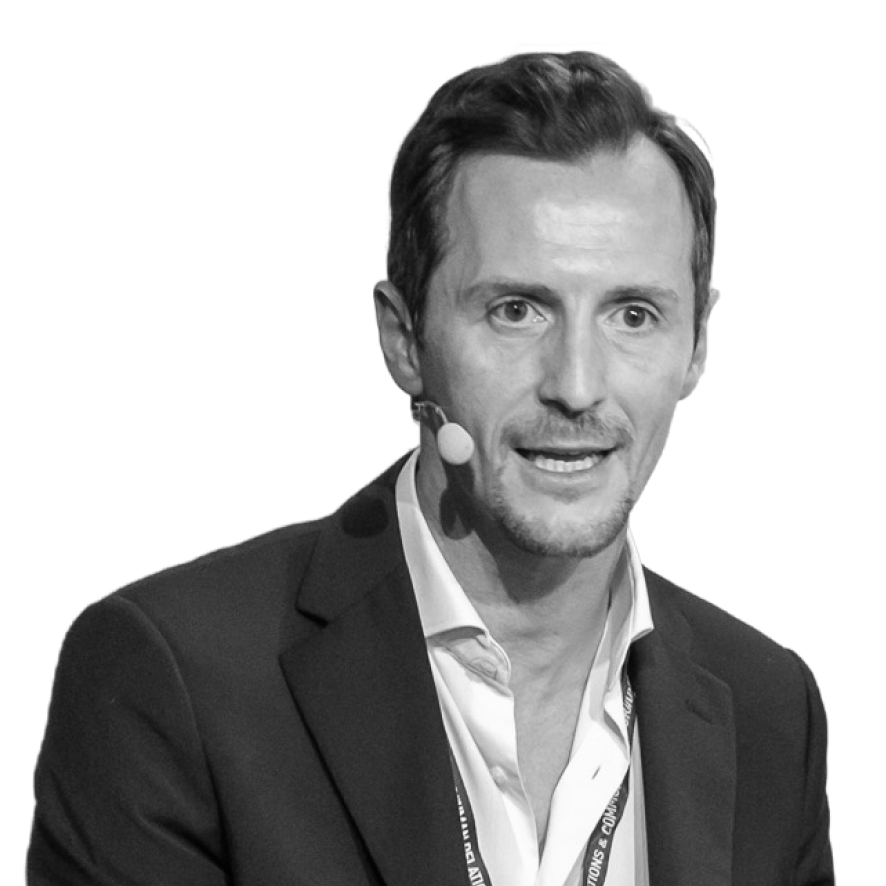 Man in a suit speaking with a headset microphone.