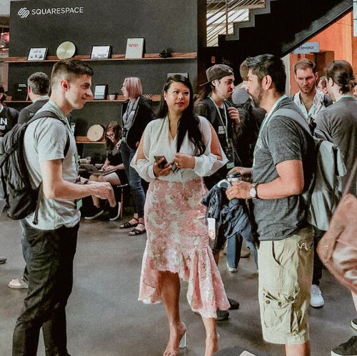 Attendees talking to a speaker in the main lobby between talks