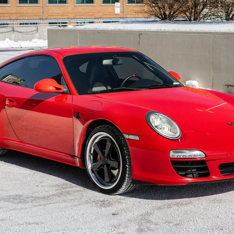 Red sports car photographed outdoors on a snowy lot