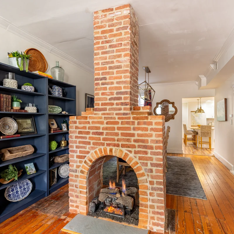Real estate interior photo of a living room with a brick fireplace