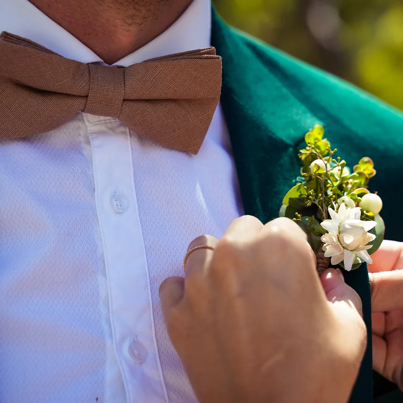 Wedding detail photo of a groom’s bow tie and boutonniere