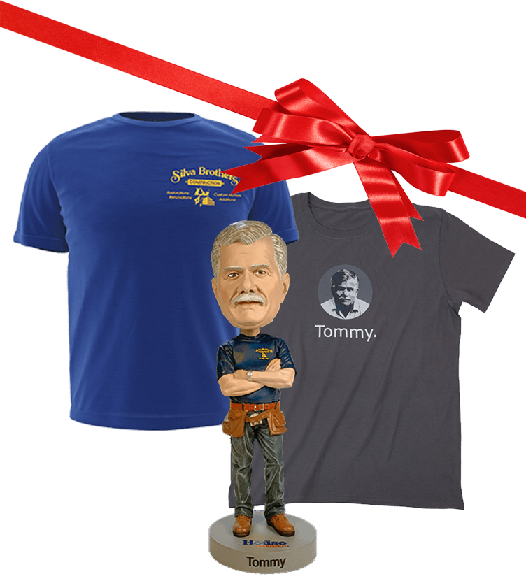 Gift bundle with a blue Silva Brothers Construction t-shirt, a dark gray t-shirt featuring an image of Tommy and the text 'Tommy.', and a Tommy bobblehead figure wearing a tool belt, all tied with a red ribbon bow.