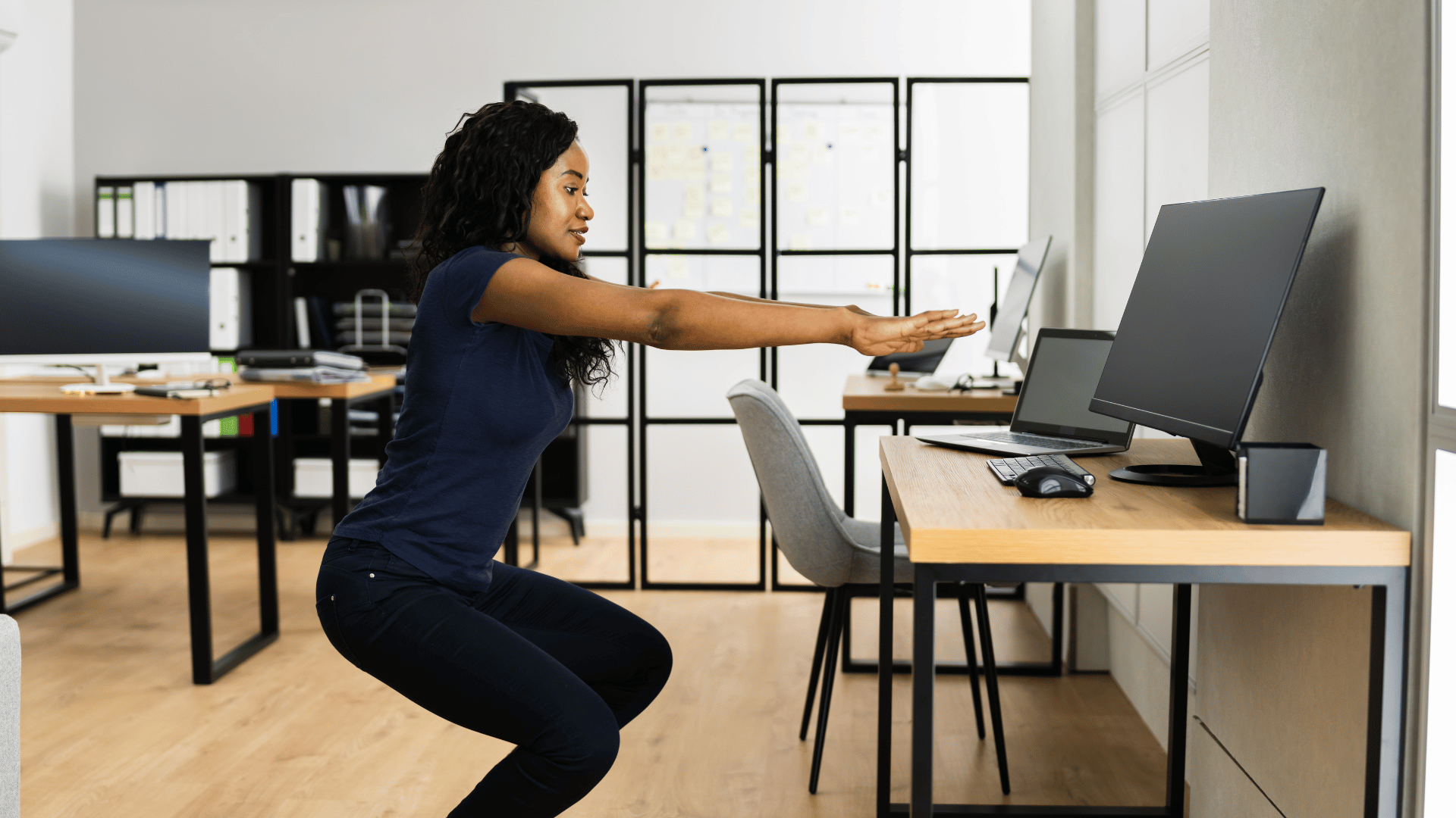 Employee stretching at her office desk