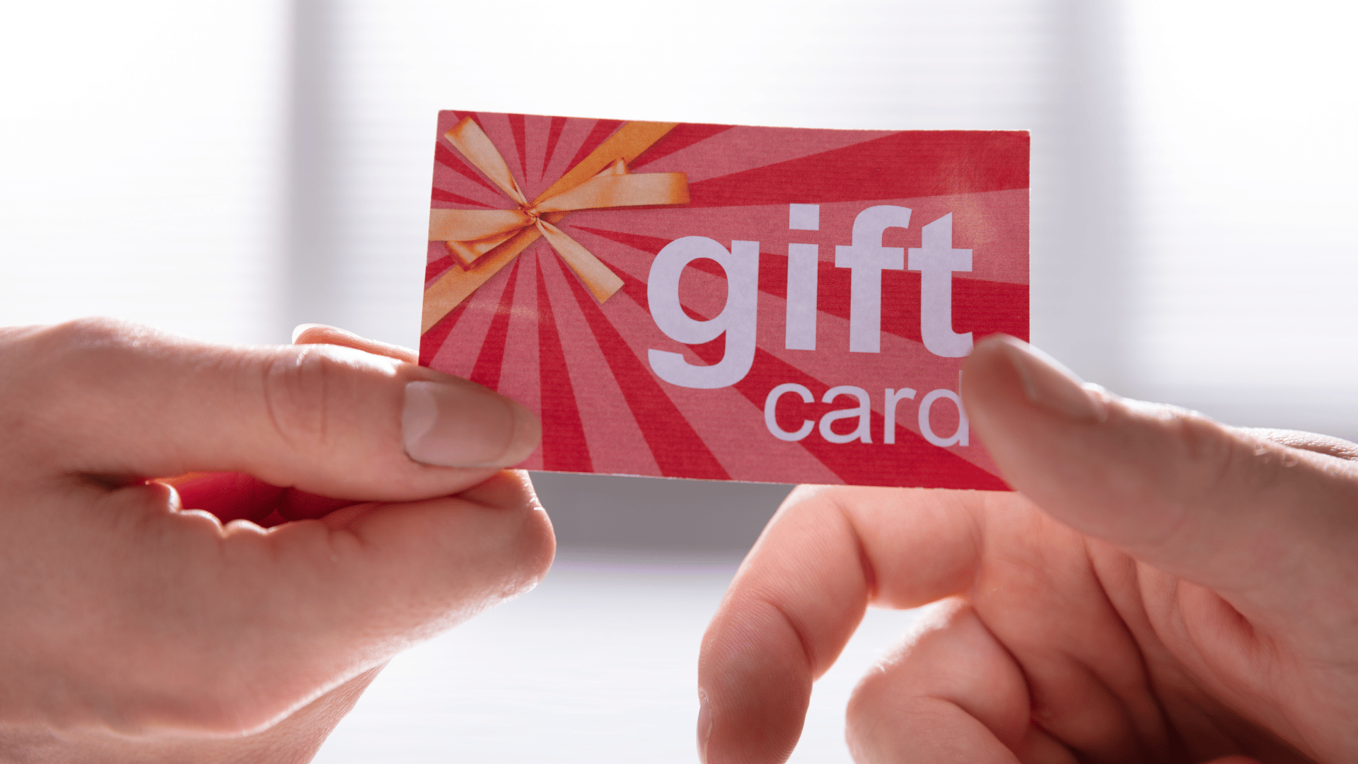 Person handing another person a gift card