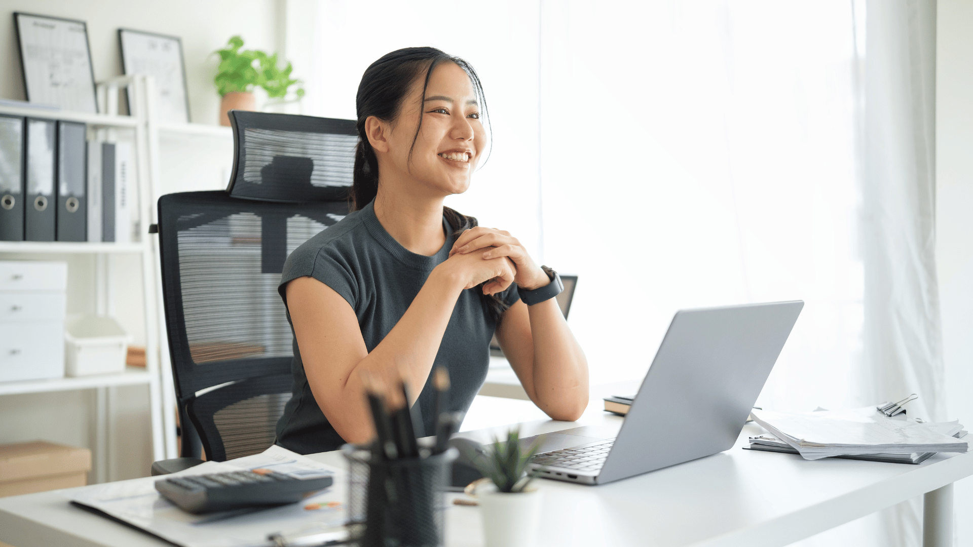 Woman smiling while sitting in her home office