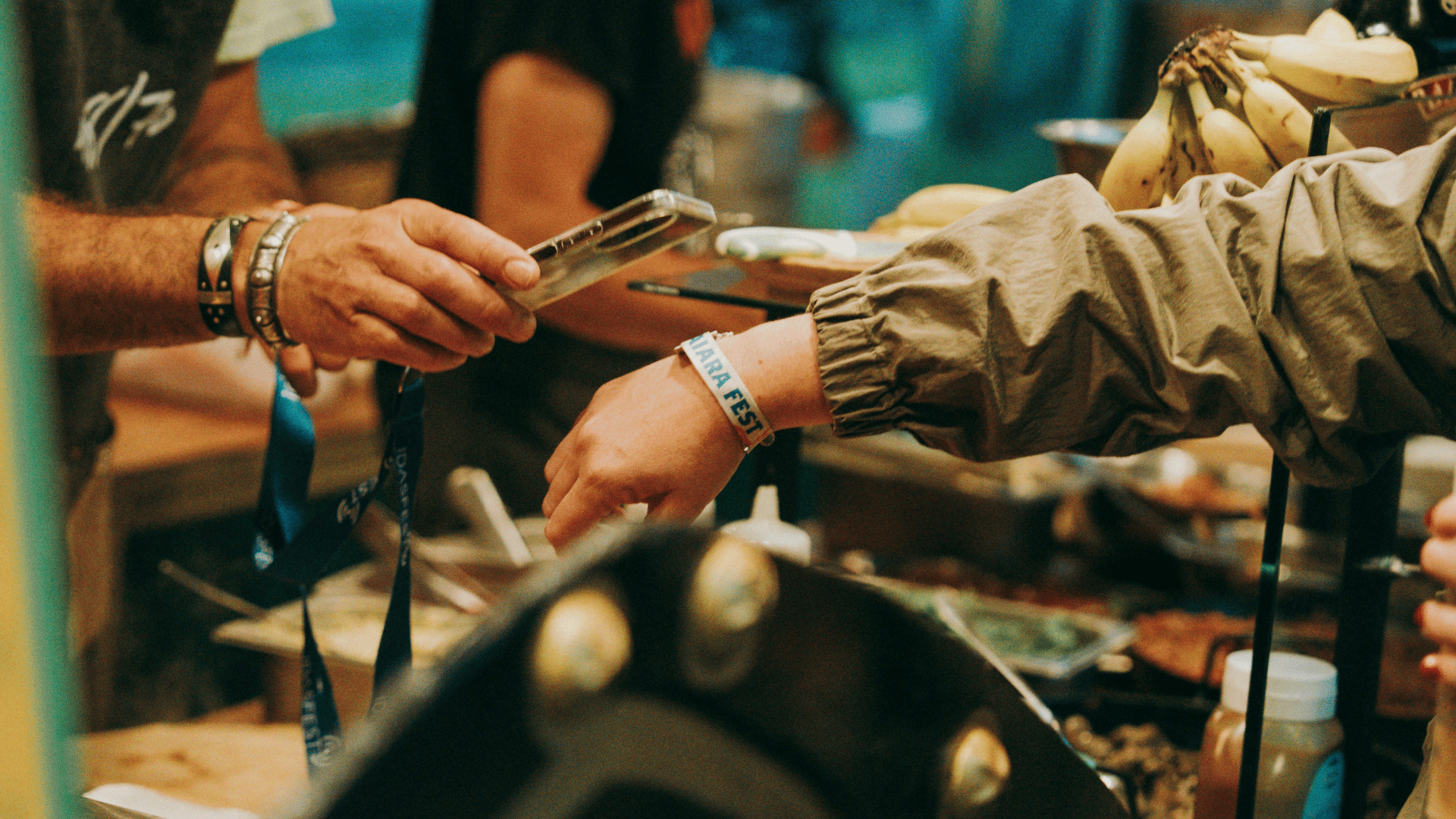 Festival-goer showing their wristband to staff