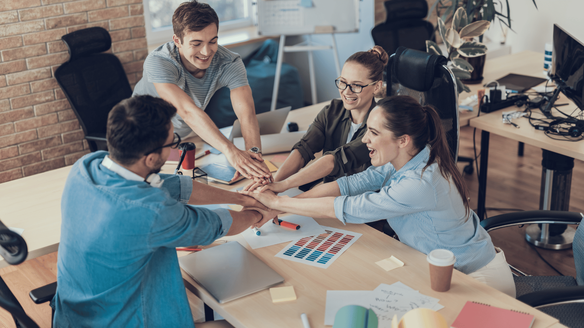 Team huddle with hands-in at the office