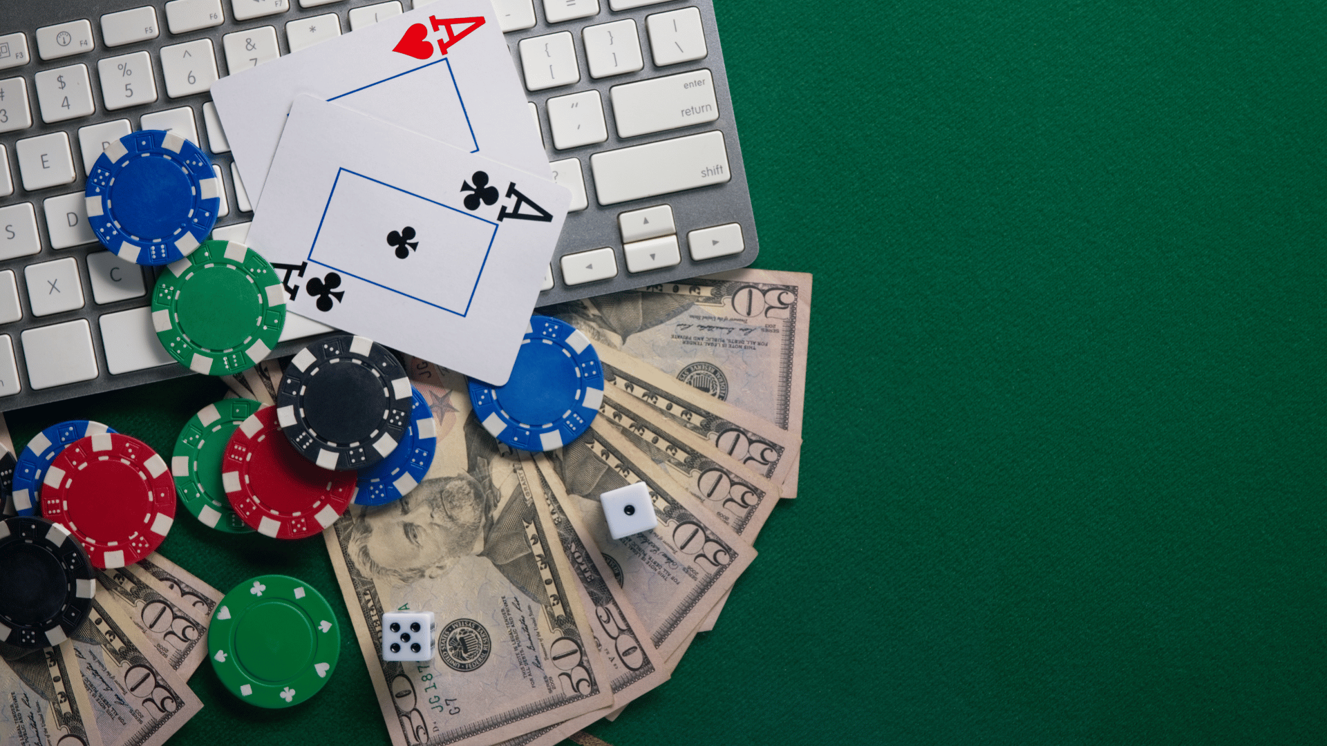 Cards, money, and poker chips on top of a laptop