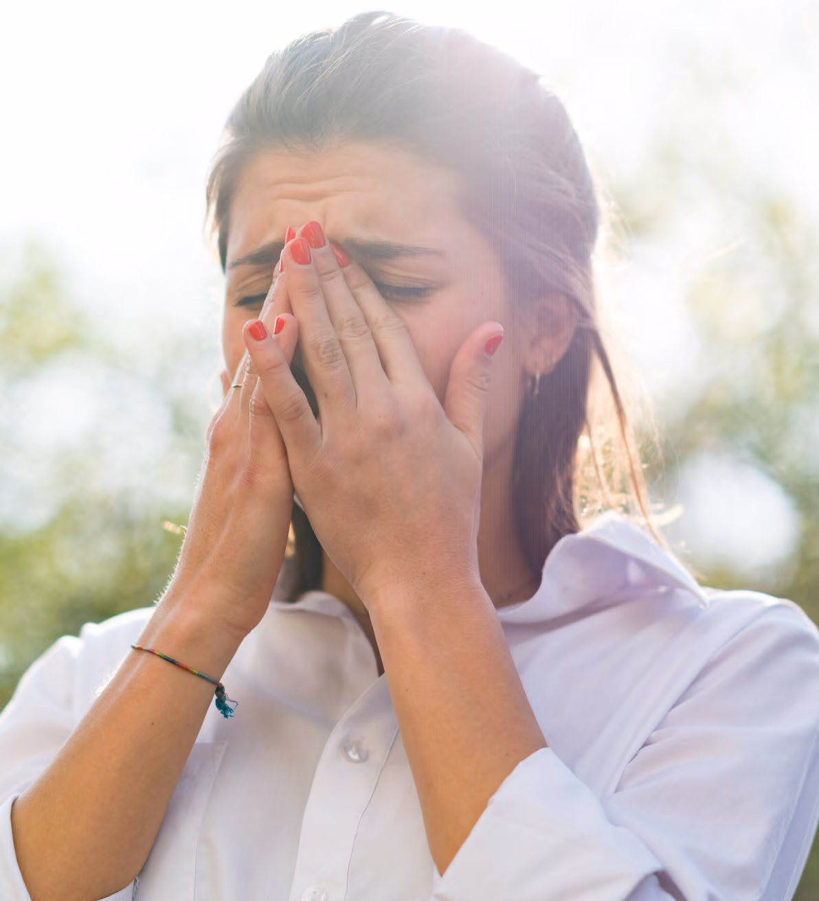 woman holding her head, suffering from allergies