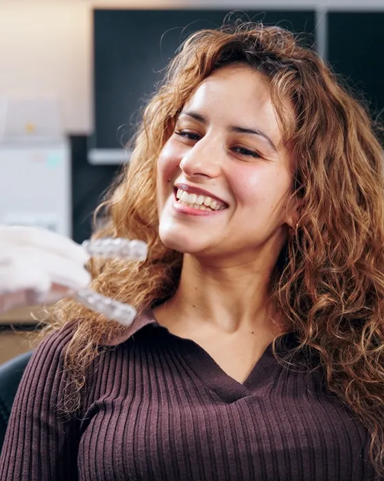 Lachende Frau, die eine Aligner-Schiene testet