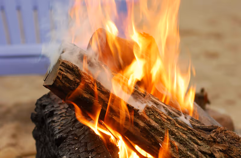 Close-up of a burning bonfire with wooden logs and bright orange flames.