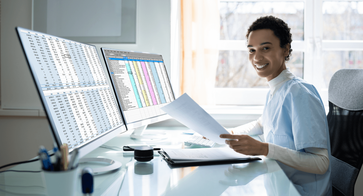 A medical biller smiles at their desk