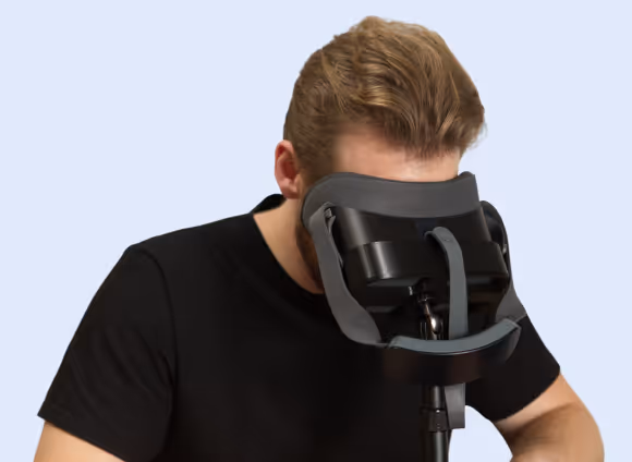 A man looks into Virtual Field placed in a headset stand.