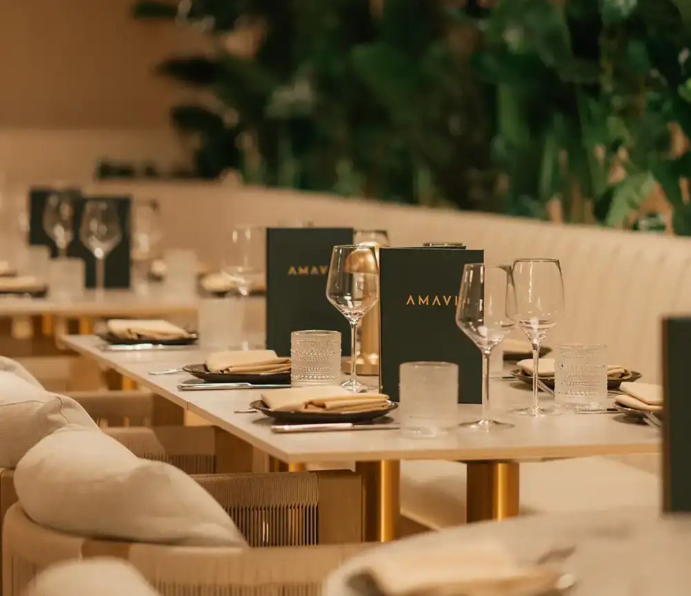 AMAVI New York dining room with cream banquettes and plants