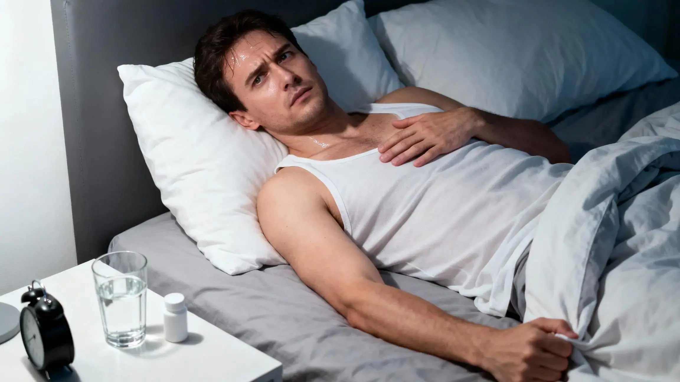 Person awake in bed at sunrise, anxious and restless, can’t sleep when hungover